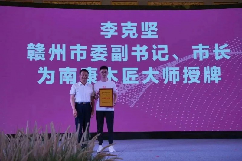 李克堅為2022年世界技能大賽特別賽家具制作項目冠軍李德鑫頒發南康木匠大師，為贛州現代家居產業發展戰略顧問頒發聘書